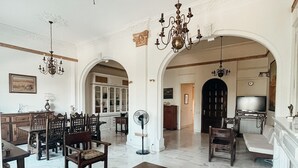 A spacious living room with a marble floor, a wooden coffee table, a red sofa, and a chandelier. - Unique sunlit house overlooking the Acropolis (Athina)