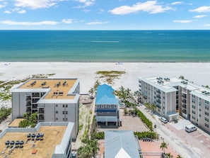 A beachfront hotel with multiple buildings, a sandy beach, and the ocean in the background. - Island Girl vacation Home (Fort Myers Beach)