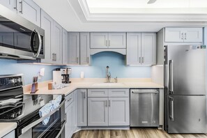 A modern kitchen with grey cabinets, stainless steel appliances, and a built-in dishwasher. - Beachfront House, Private Pool, Sleeps 8 (Fort Myers Beach)
