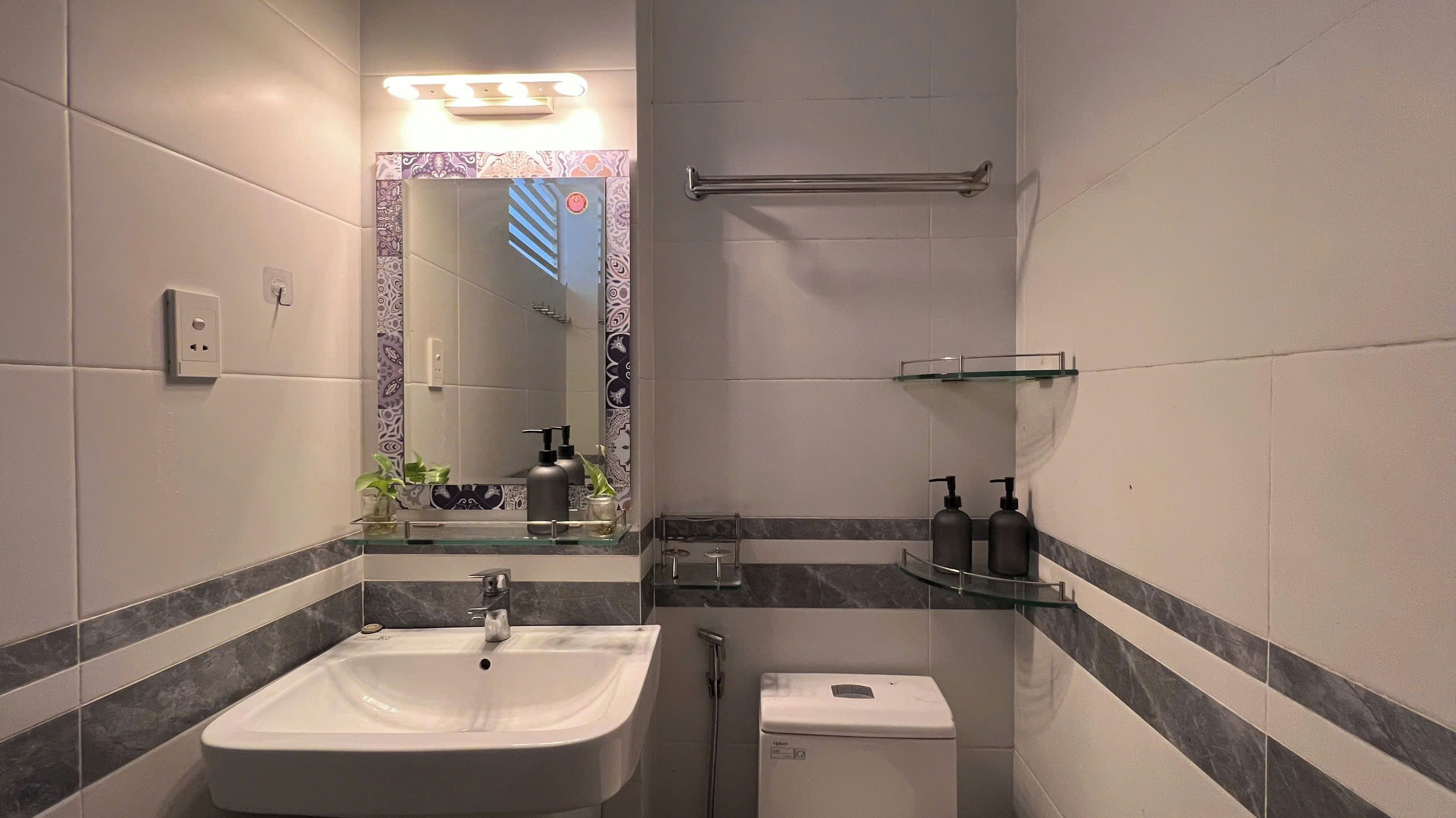 Une salle de bain moderne équipée d’un lavabo, de toilettes et d’une douche.