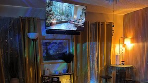 Une chambre d’hôtel équipée d’une grande télévision, d’un lit, d’un bureau et d’une chaise.
