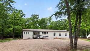 A single-story house with a front porch, a driveway, and a gravel lot. - Lake Front - Privately Owned Dock with Boat Launch (Quitman)