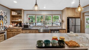 A modern kitchen with wooden cabinets, a large island, and a view of the outside. - Lake Front - Privately Owned Dock with Boat Launch (Quitman)