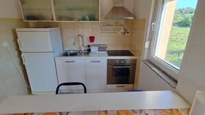A kitchen with a window, a refrigerator, a stove, and a sink. - Apartman Roko Pula -blizu centra i plaža, mirna lokacija (Pula)