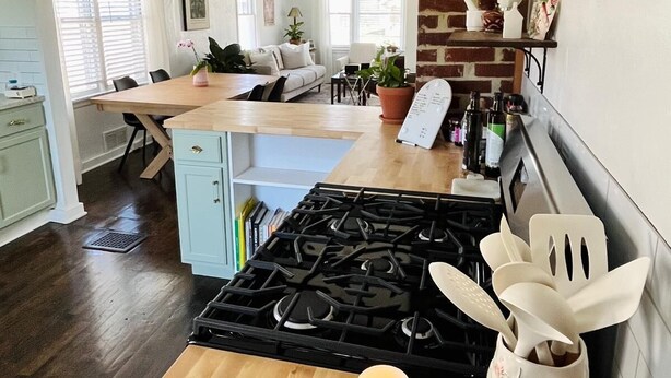 Une cuisine dotée d’un îlot central, d’une cuisinière et d’un coin repas comprenant un canapé et des chaises.