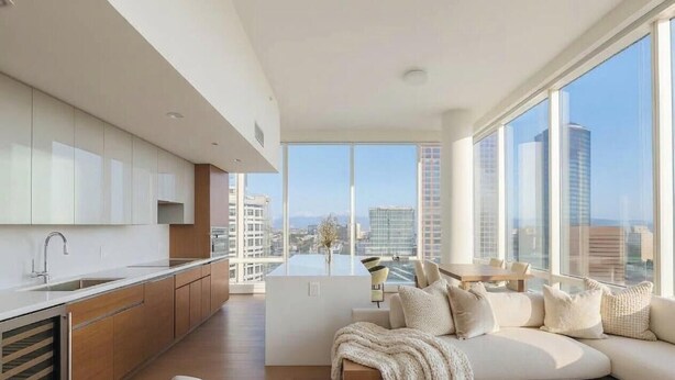 A modern kitchen with a central island, large windows, and a view of the cityscape. - Glass Loft Skyline Views + Terrace (Los Angeles)
