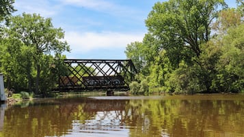 Een brug over een rustige rivier, met bomen aan beide oevers.