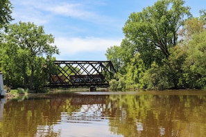 A bridge over a calm river with trees on either side.