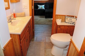 Et badeværelse med vask, toilet og et skilt, der siger 'GONE FISHING'.