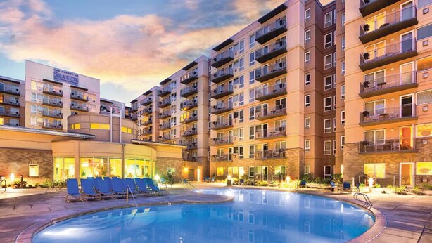 Ein Hotel mit Schwimmbad, mehreren Etagen und Balkonen.