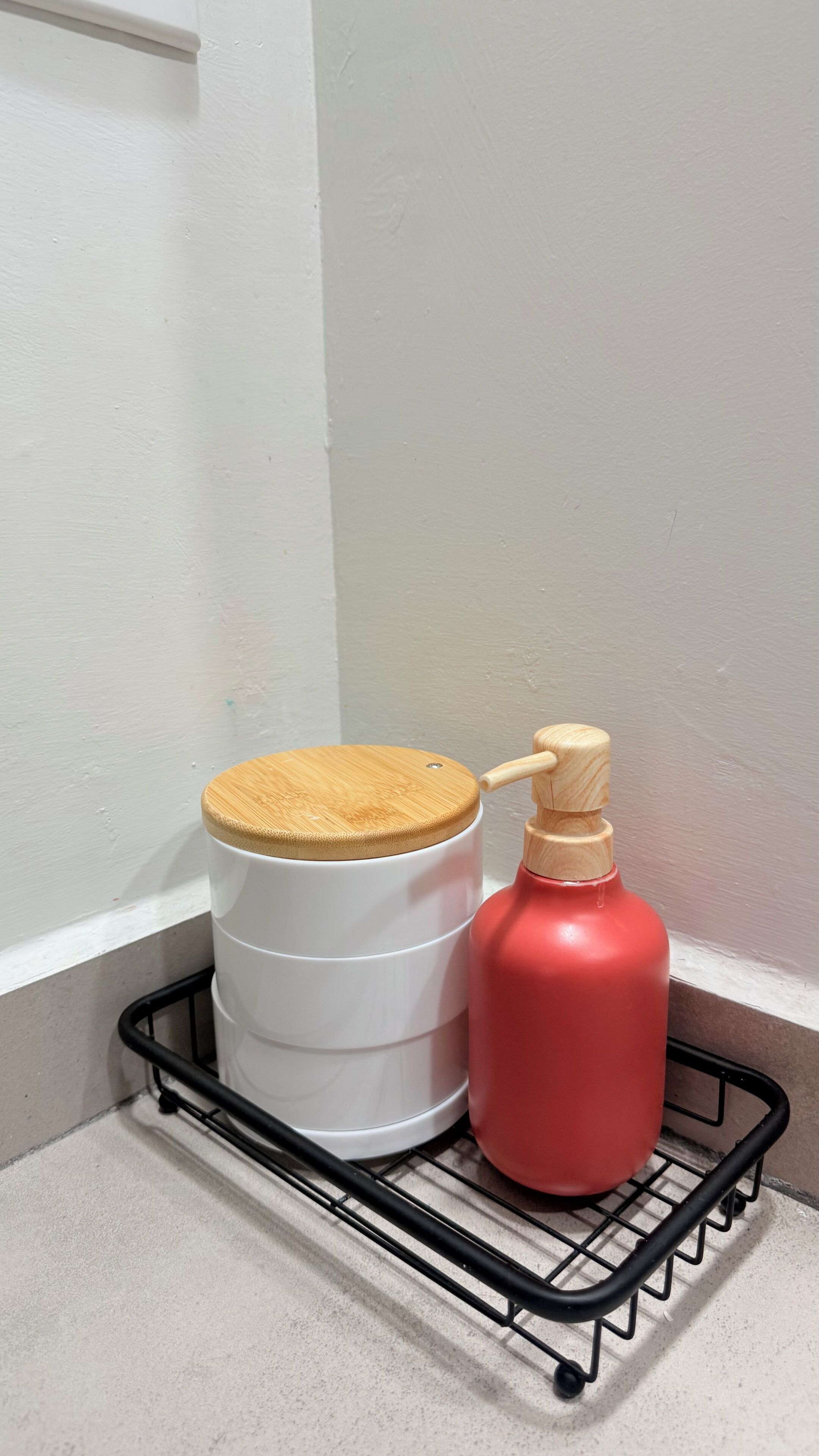Een hoekplankje met een witte cilindrische container en een rode gasfles.