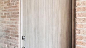 Una puerta con el número 103, un cierre con teclado numérico y una cámara de seguridad encima.