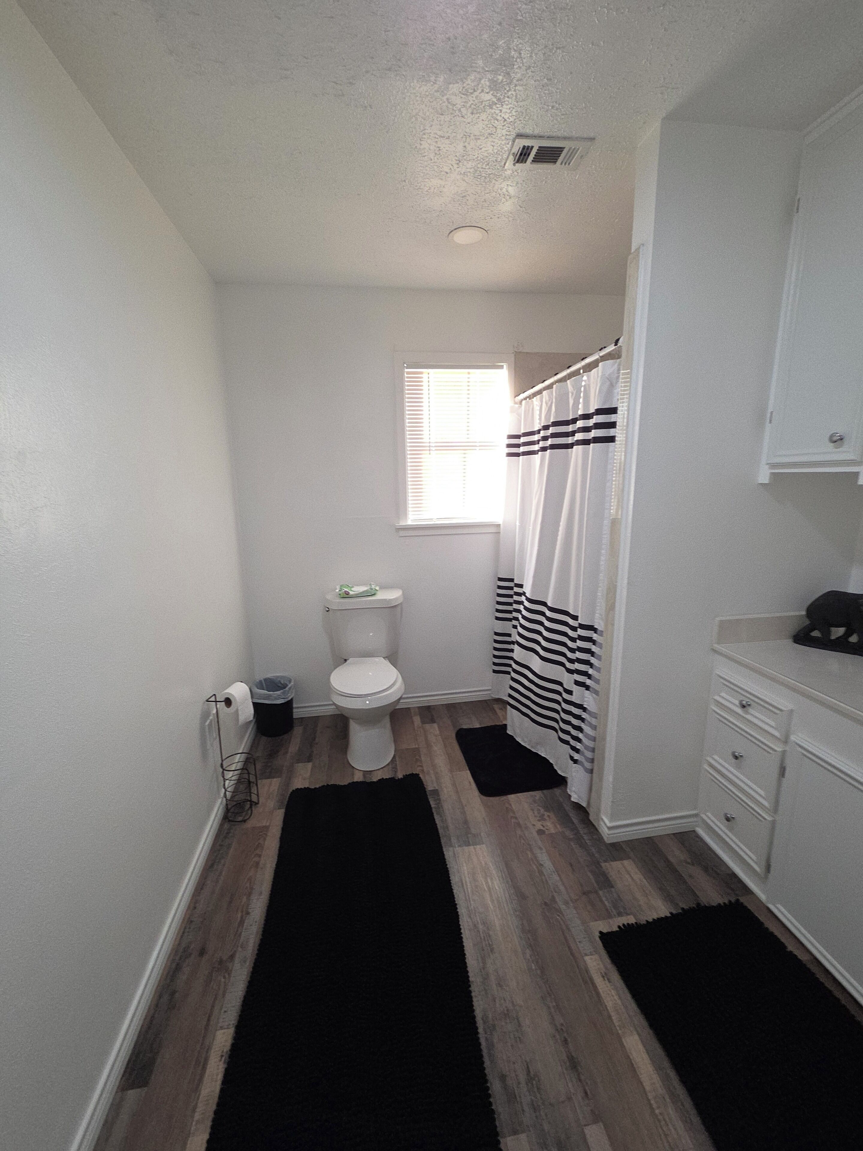 A small bathroom with a toilet, sink, and shower curtain.