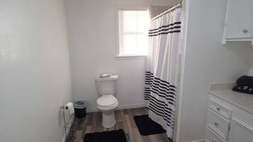 A small bathroom with a toilet, sink, and shower curtain.