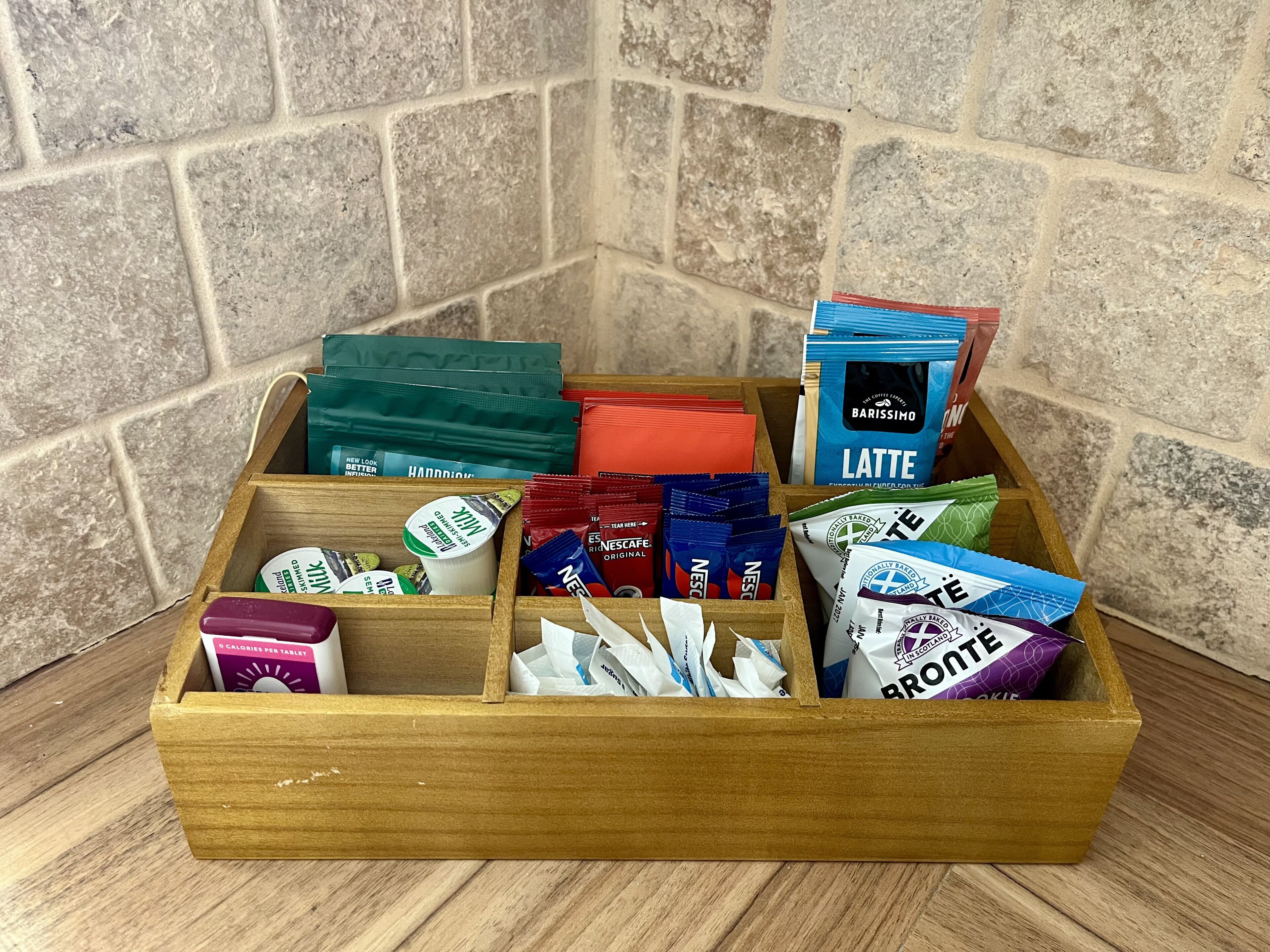 A wooden box containing various coffee and tea products.