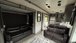 Ein kompaktes Wohnmobil-Interieur mit einer Sitzecke, einer Essecke und einer Küchenzeile.