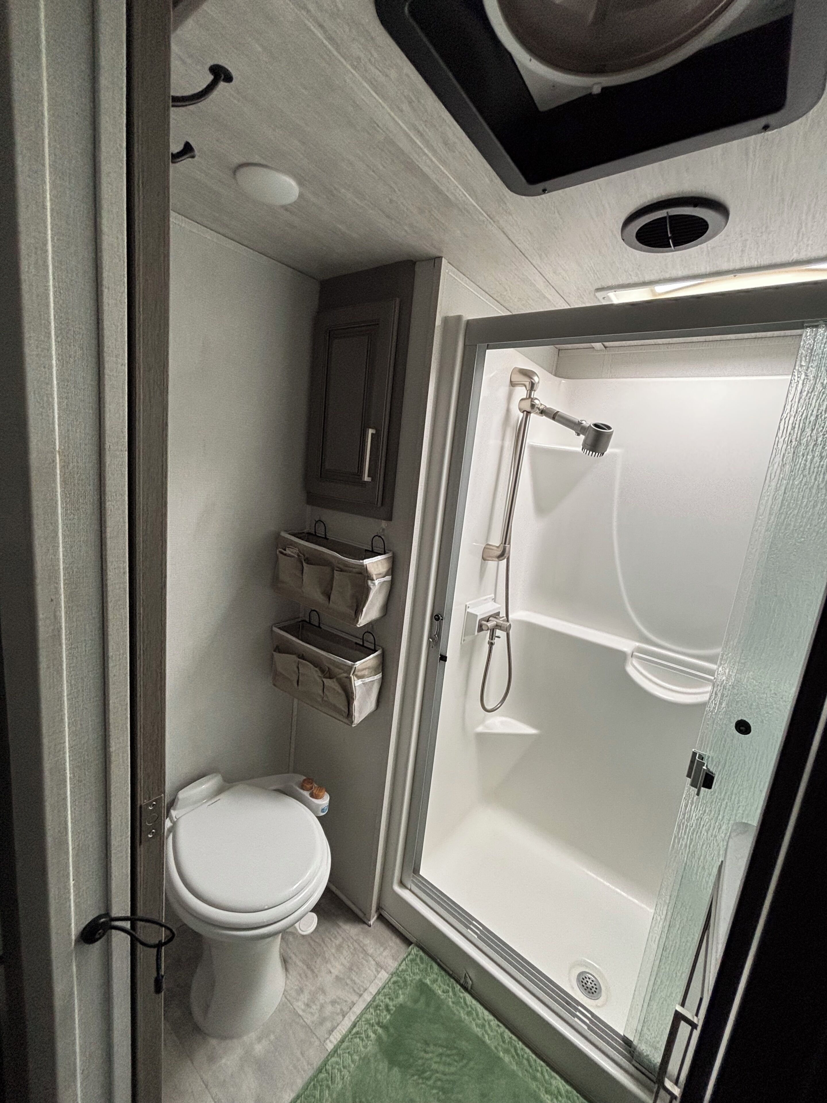 Un bagno piccolo ma funzionale, con il water, box doccia e un armadietto.
