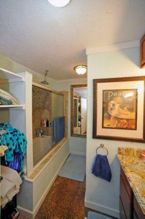 Ein Badezimmer mit Dusche, Handtuchhalter und einem gerahmten Bild an der Wand.