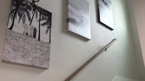 Eine Treppe mit Handlauf und drei gerahmten Bildern an der Wand.