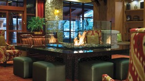 A lobby with a glass-top fire feature, leather seating, and a stone pillar. - Beautiful spacious 2-bedroom condo in fabulous South Lake Tahoe (South Lake Tahoe)