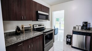 Una cocina moderna con armarios de madera oscura, electrodomésticos de acero inoxidable y encimeras de granito.