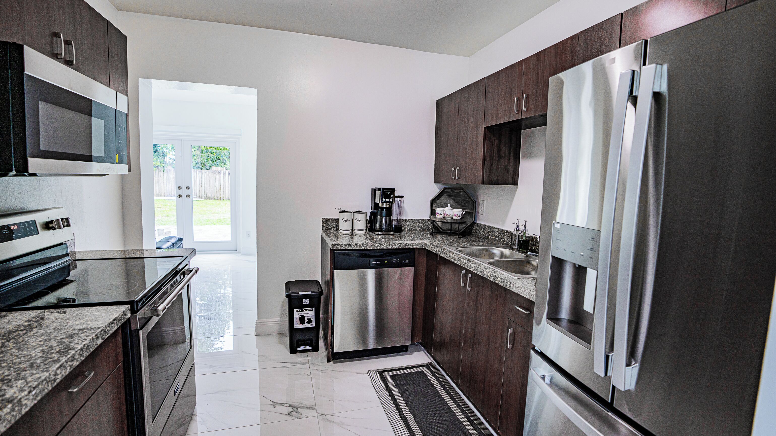 A modern kitchen with stainless steel appliances, a dishwasher, and a coffee maker.