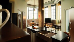 A kitchen with a central island, a built-in oven, and a large window. - Cooperage 214 | 2BD Boutique Loft Stay (Peoria)