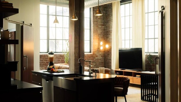 A modern kitchen with a central island, a built-in stove, and a large window. - Cooperage 214 | 2BD Boutique Loft Stay (Peoria)