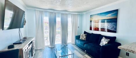Condo, varias camas, balcón, vista al océano (Sandy Seawall Escape) | Área de sala de estar