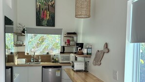 Une cuisine moderne dotée d’un plan de travail en bois, d’appareils électroménagers en acier inoxydable et d’un coin repas avec un banc.