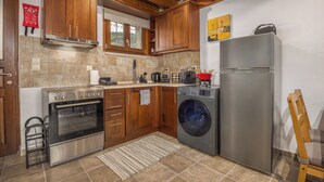 Une cuisine avec des meubles en bois, un four en acier inoxydable, un lave-linge et un réfrigérateur.