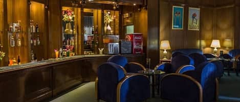 A bar area with a counter, seating, and decor.