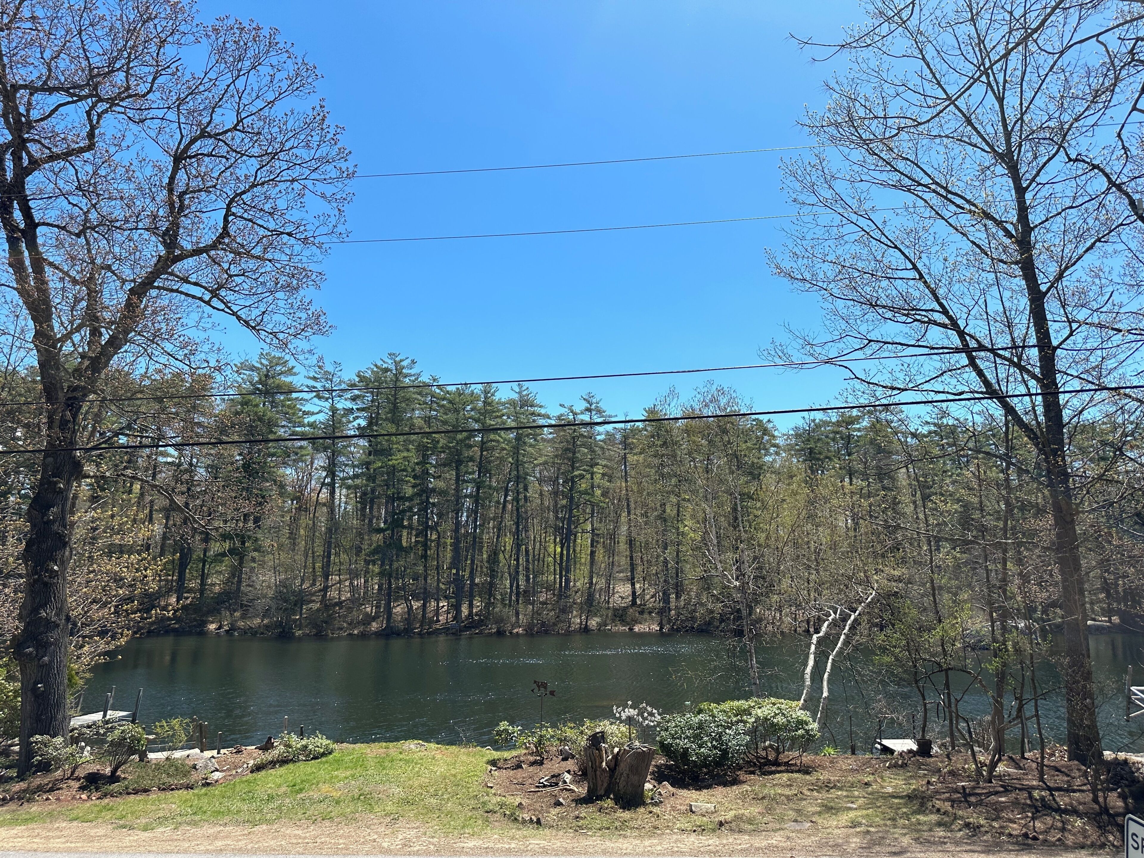 Une vue sur le lac, avec des arbres, un quai et un ciel dégagé.