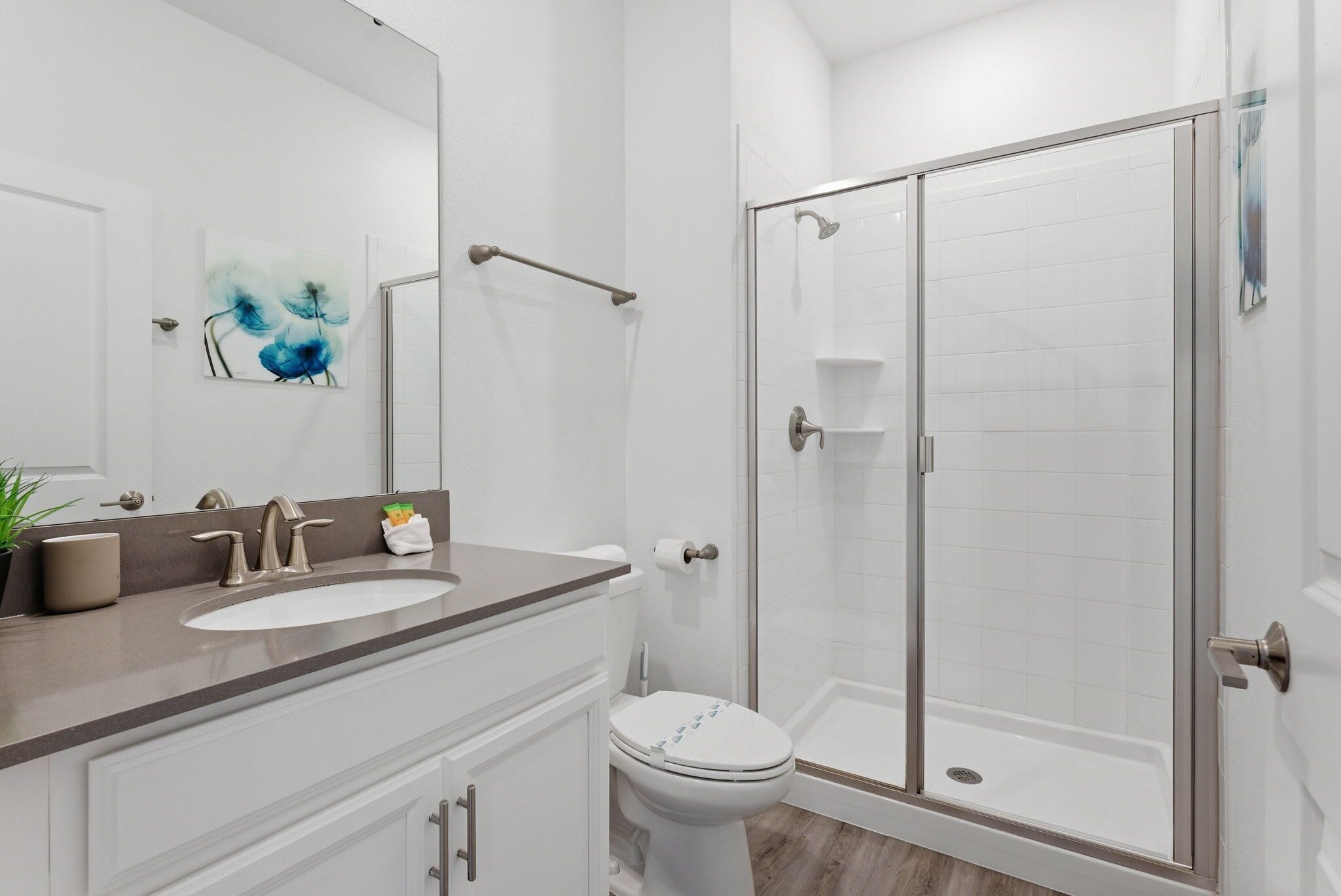 A bathroom with a sink, toilet, and glass-enclosed shower.