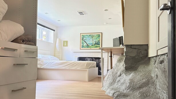 Un dormitorio moderno con una cama, un aparador y un cuadro en la pared.