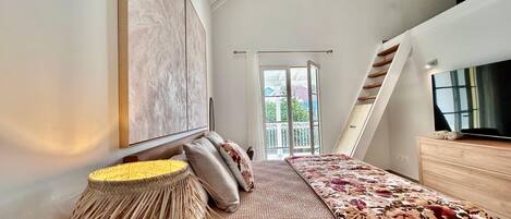 Un dormitorio moderno con una cama grande, un televisor y vistas al exterior.