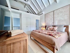 A bedroom with a wooden bed, a wardrobe, and a ceiling with skylights.
