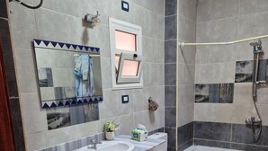 A bathroom with a washing machine, two sinks, a toilet, a bathtub, and a shower. - Star Apartment 2 Hurghada (Hurghada)
