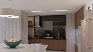 Uma cozinha moderna com ilha central, fogão embutido e uma janela grande.