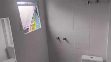 Chuveiro, toalhas de banho, sabonete, papel higiênico