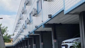 A row of numbered parking garages with a white car parked in one. - Hotel Paraty (São Paulo)