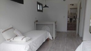 Une chambre à coucher avec un lit, une table de chevet et une petite cheminée.