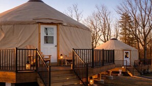 A yurt with a wooden deck, a door, and a small porch area with railings. - Goldfinch Yurt - Scenic Mountain Retreat (Rising Fawn)