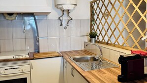 Una cocina moderna con estufa integrada, un lavamanos y calentador de agua.