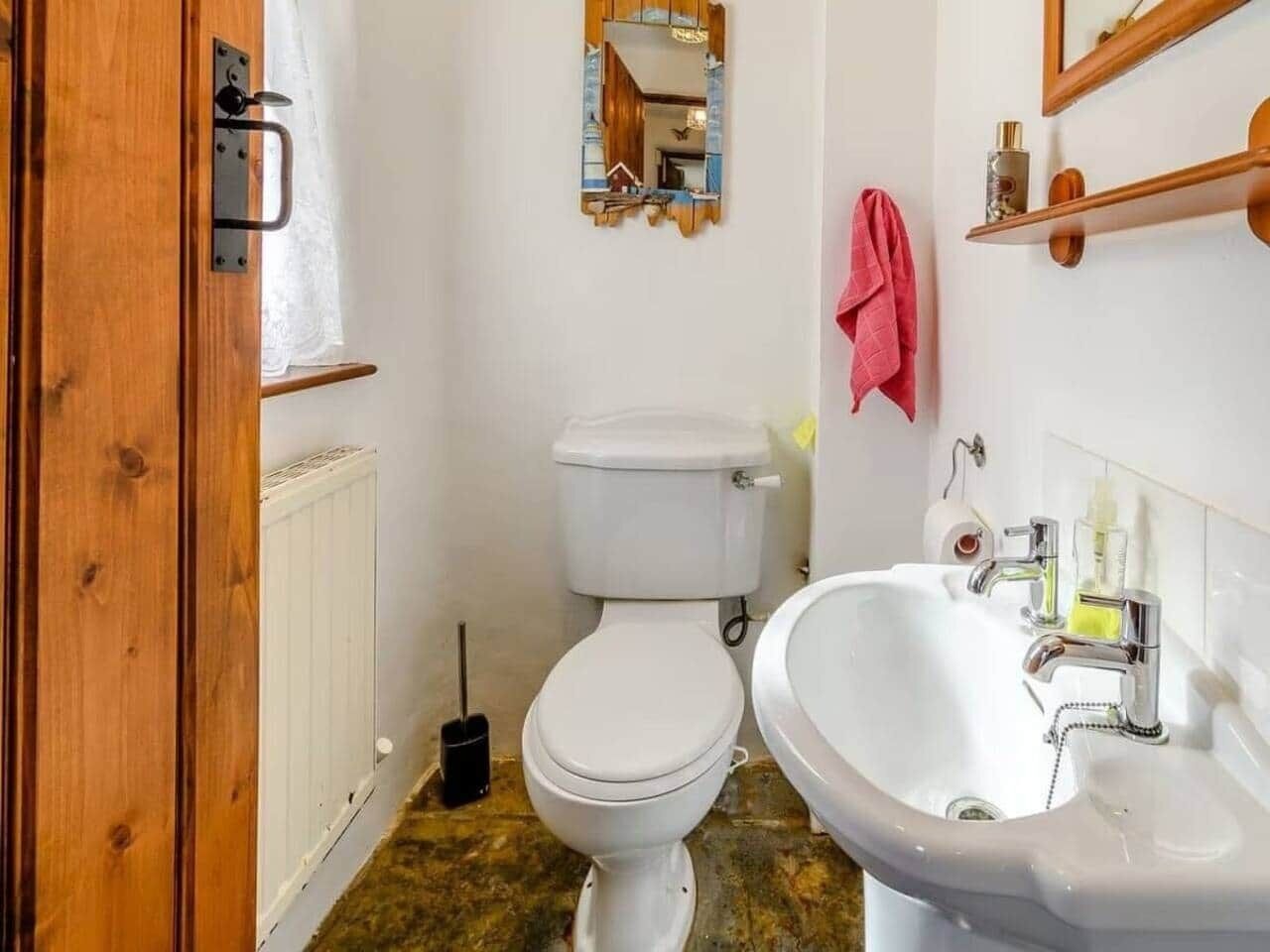 Un baño con inodoro, lavabo y espejo.