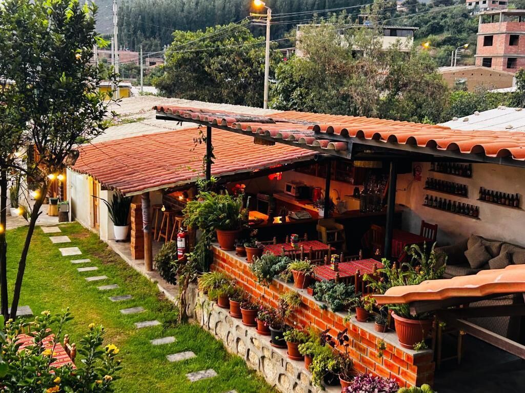 Un restaurante con terraza, pared de ladrillo y plantas en macetas.