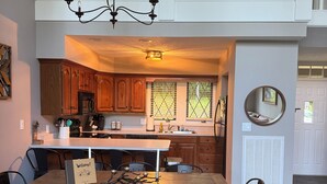 Cocina amplia con comedor, armarios de madera y una araña.