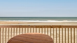 Blick auf den Strand vom Balkon aus, mit einem Holztisch.