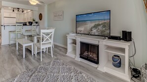 Ein Wohnzimmer mit Kamin, Fernseher und Essbereich mit weißer Möbel.