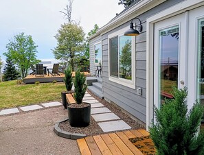 Moderni talo, jossa on terassi, ulkotila istumiseen ja suuri ikkuna.